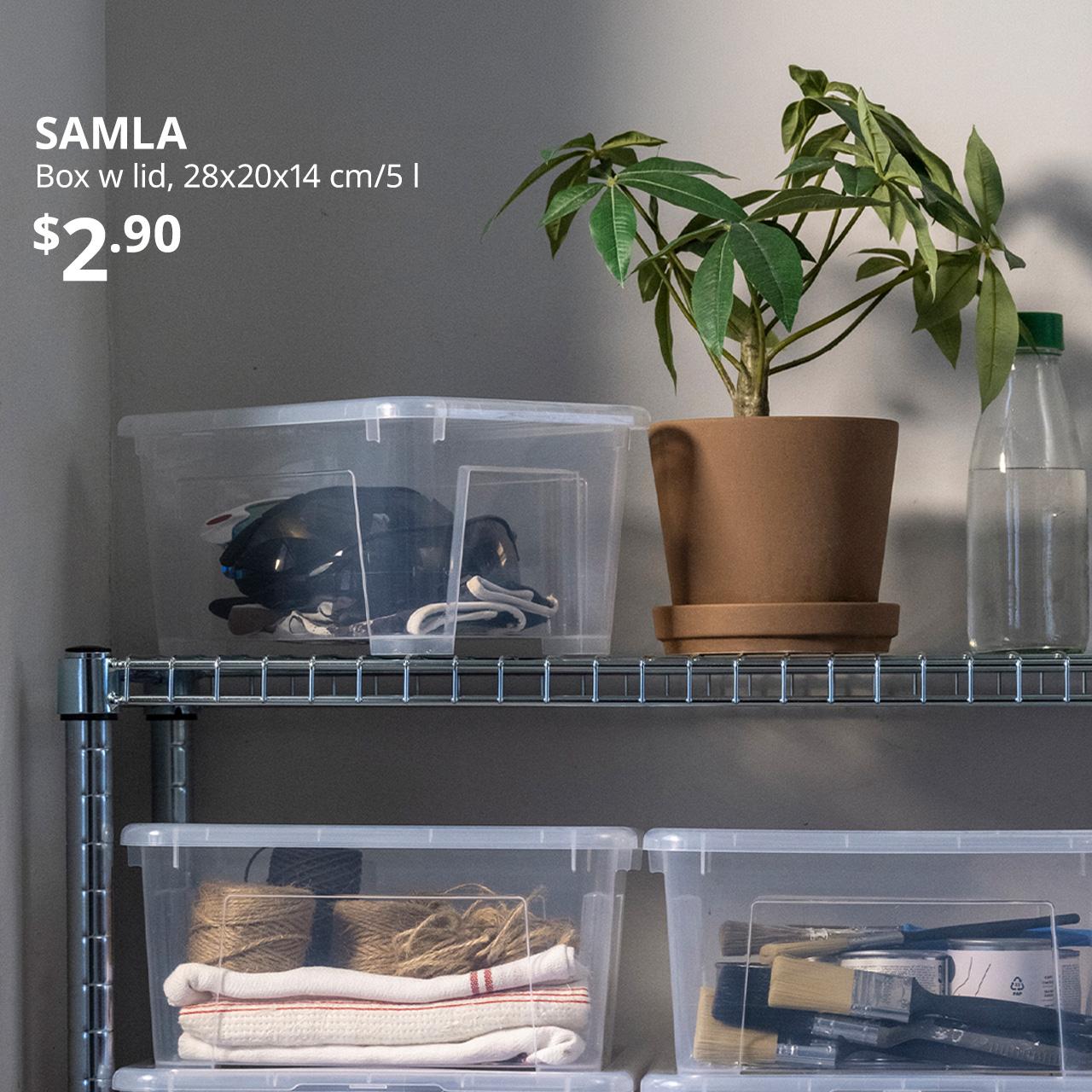 A close-up shot of SAMLA boxes on a s galvanised OMAR shelving. The product being called out is the transparent SAMLA box with lid next to the potted plant on the top shelf of OMAR. White text overlaying image on the top left corner that reads 'SAMLA, Box with lid, 28x20x14 cm/5l, $2.90'.