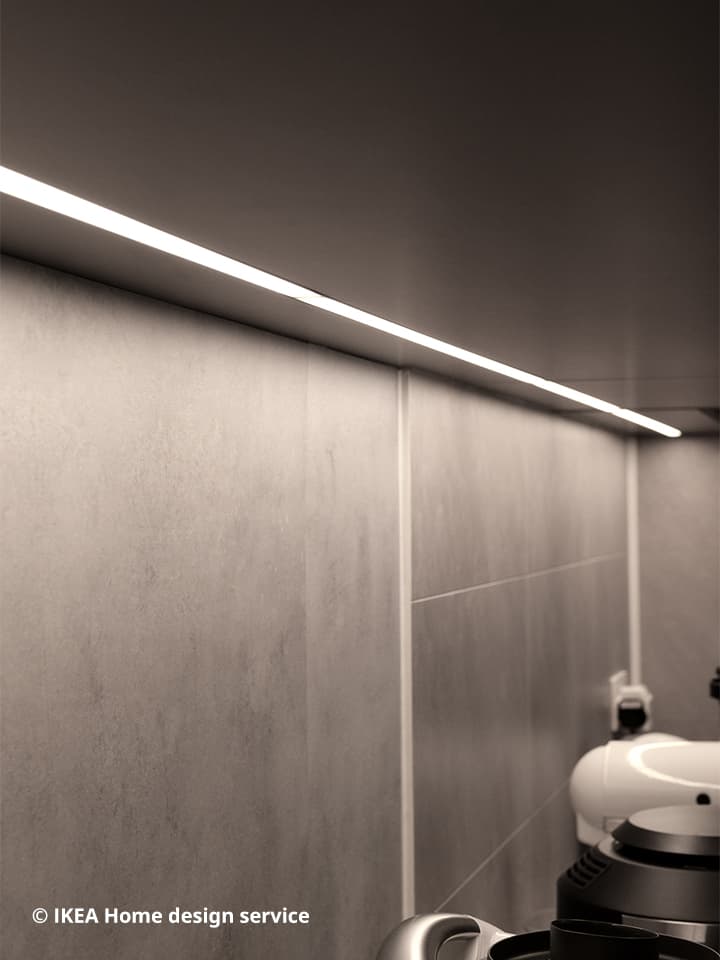 A close up view of integrated lighting installed within an IKEA METOD kitchen system with grey door fronts and cabinets.