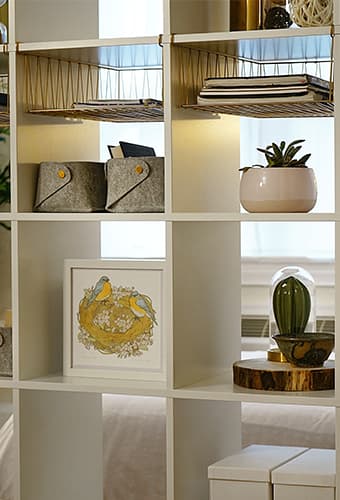 Detail of KALLAX shelving unit with plants, framed artwork and boxes on it's shelves. #ikeahacks #kallax #roomdivider