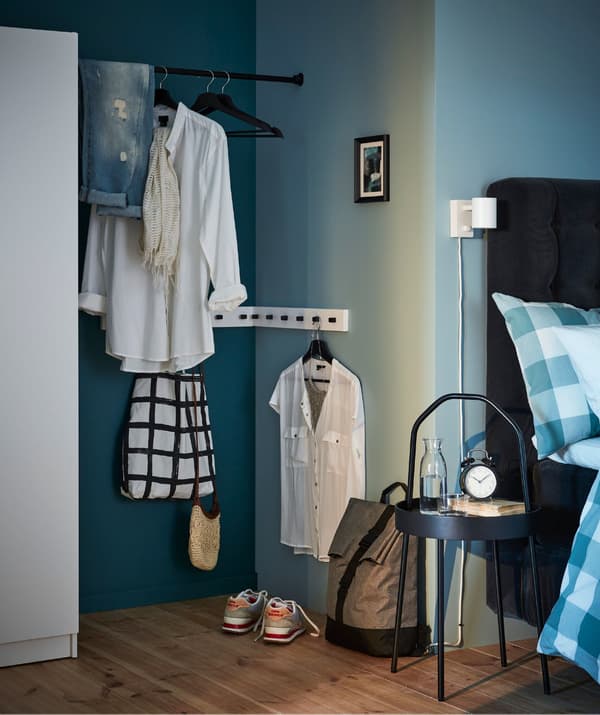 A clothes changing nook created from an awkward space between a closet and the corner of a room.