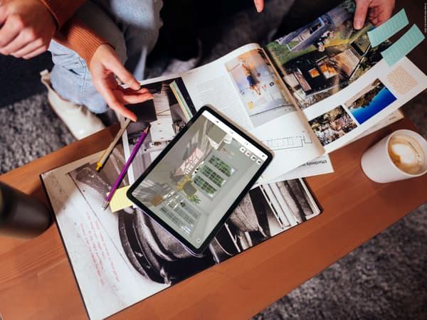 A coffee table with a tablet on it with an opened IKEA kreativ design. On the table are also magazines with design inspiration.
