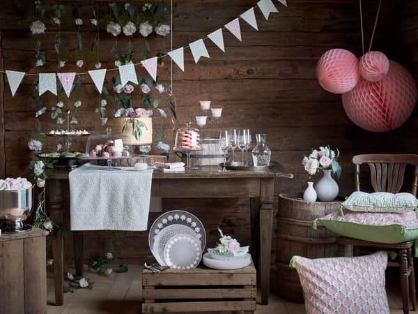 A collection of products from the INBJUDEN collection including several plates, dishes, pillows and decorations.