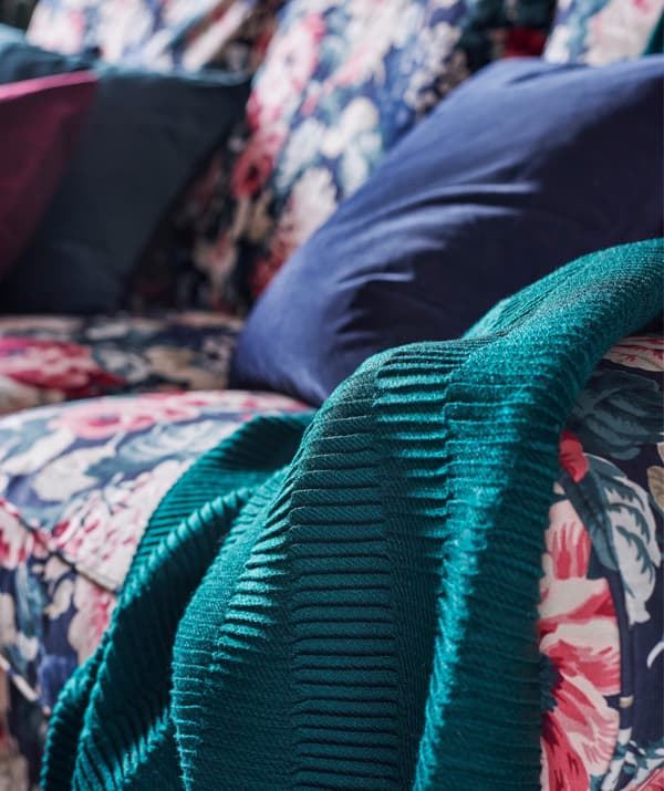 A colour palette with a mix of warm and dark tones can take a living room from feeling cosy in the daytime to mysterious at night.