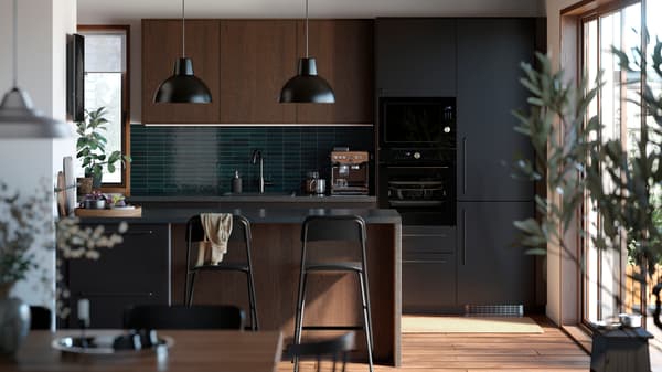 A contemporary kitchen with a kitchen island and a combination of brown SINARP fronts and NICKEBO fronts in matt anthracite.