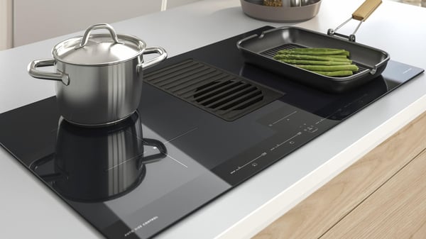 A cooktop with a pot and pan cooking on it.