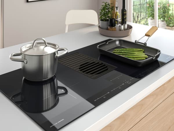 A cooktop with a pot and pan cooking on it.