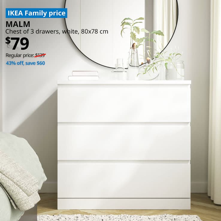 A corner shot of a bedroom setting with a white MALM chest of 3 drawers with a black LINDBYN mirror hung above it. A blue tag with white text that reads 'IKEA Family price', followed by white text overlaying image that reads 'MALM, Chest of 3 drawers, $79, Regular price: $139.'