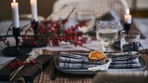 A cosy and festive table decorated with natural fibres and foraged ornaments.