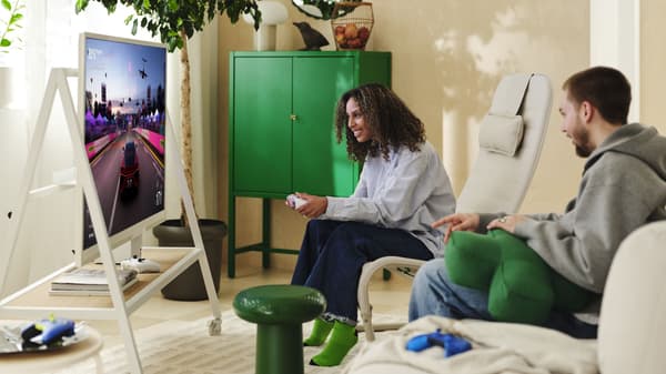 A couple is gaming in the living room surrounded by products from the YXSTABY collection.