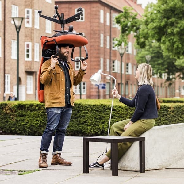 A couple on the street holding furniture 