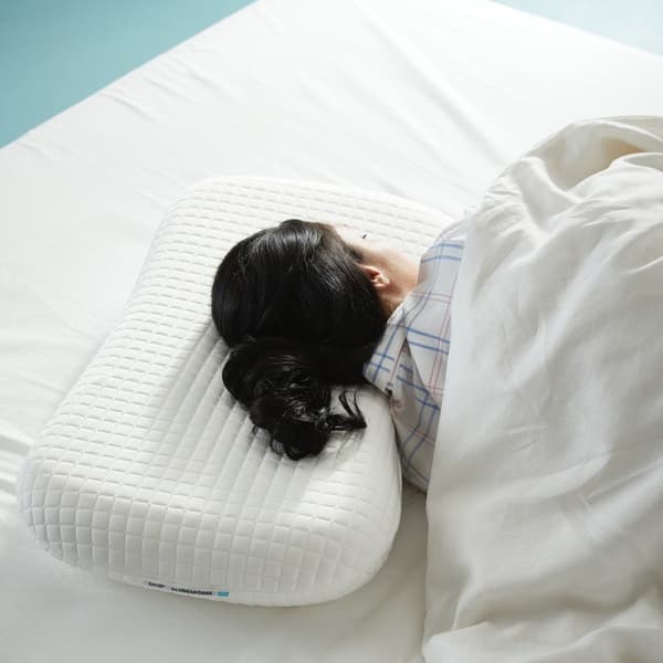 A couple sprawl across a double bed with black and white SKUGGBRÄCKA bed linen and a VÅRELD bedspread, deep in sleep.
