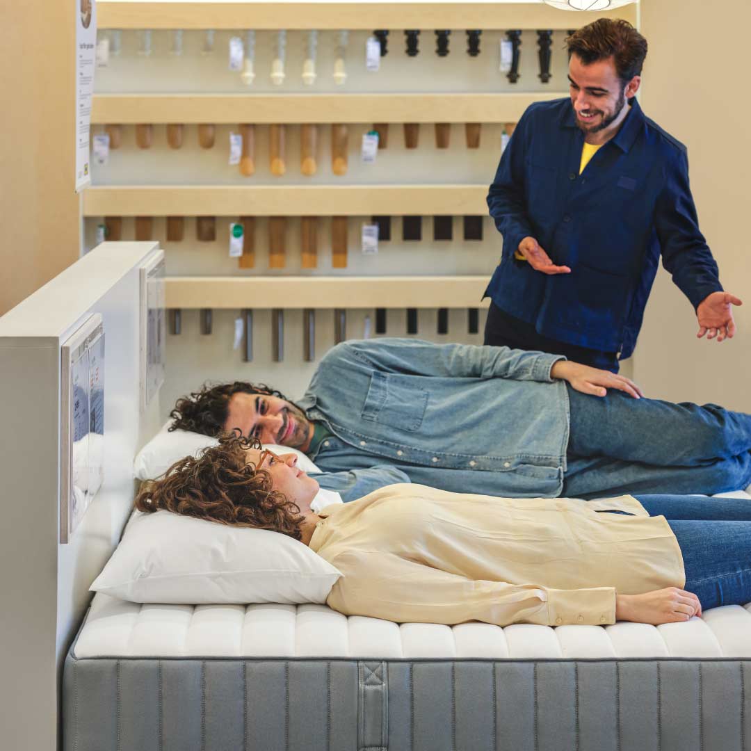 A coworker attends to customers on how to choose the right mattress