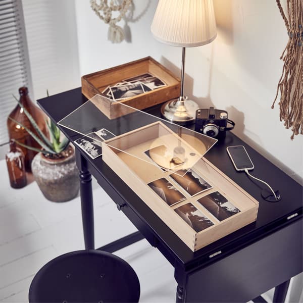 A creative corner in a bedroom with an IKEA INGATORP desk, lamp and an unfinished art project.