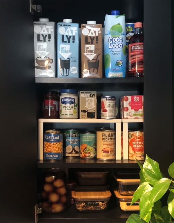 A cupboard with VARIERA shelf insert storing tins and jars.