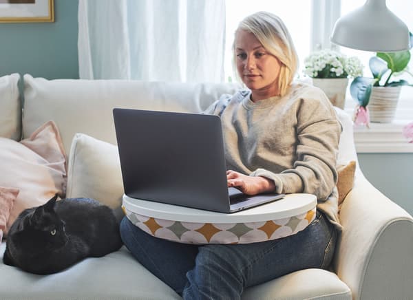 A customer browsing the IKEA website on their laptop while sitting on the sofa