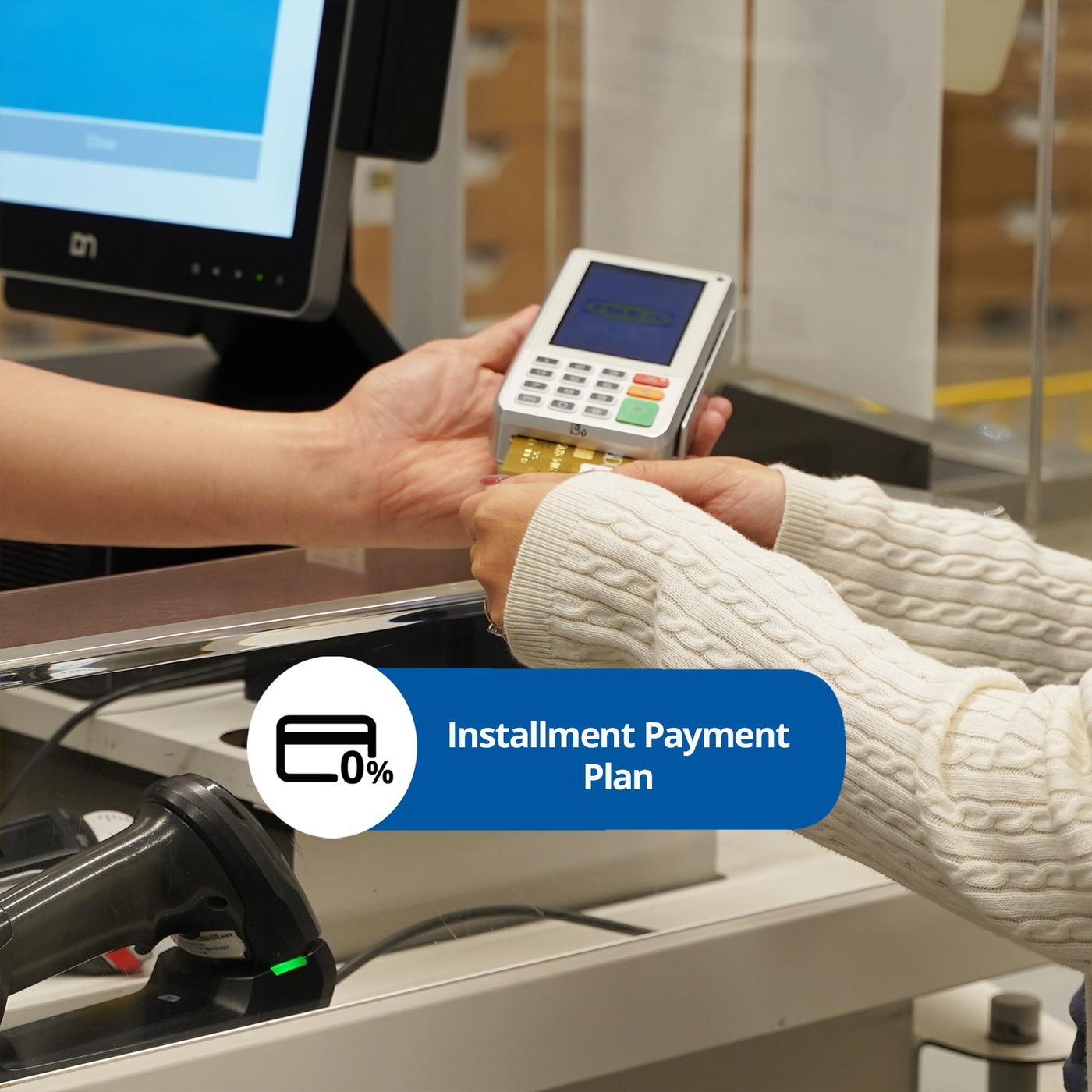 A customer hands a payment card to a cashier at a checkout, with a digital display showing an installment payment plan option.