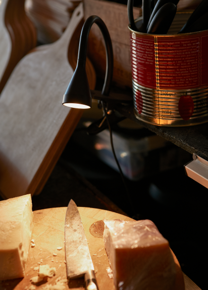 A cutting board with a knife and cheese on it
