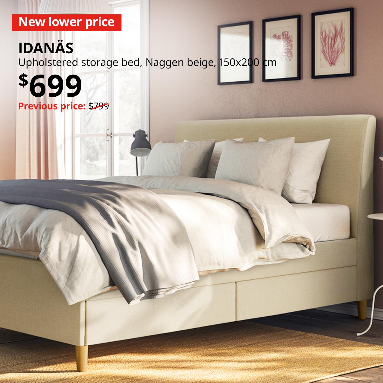 A dark brown IDANAS bed frame in the middle of a bedroom, with white and grey covers and sheets.  A red "New lower price" label is on the top left of the image with white text that reads: IDANAS, Bed frame, queen, Price at $699, Previous price, $799.