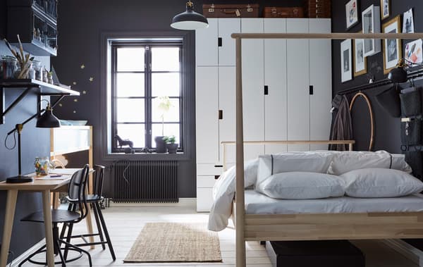 A dark grey and white bedroom that’s shared by a parent and child with an adult’s bed, child’s loft bed, wardrobes and a desk