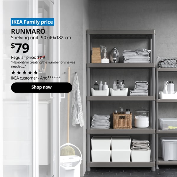 A dark grey RUNMARÖ shelving unit in the service yard. A blue tag with white text that reads 