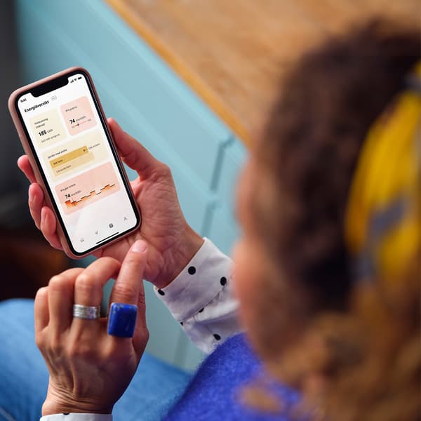 A dark haired woman looking at the energy insights app from IKEA