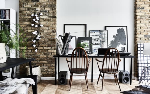 A desk for two people with monochrome artwork.