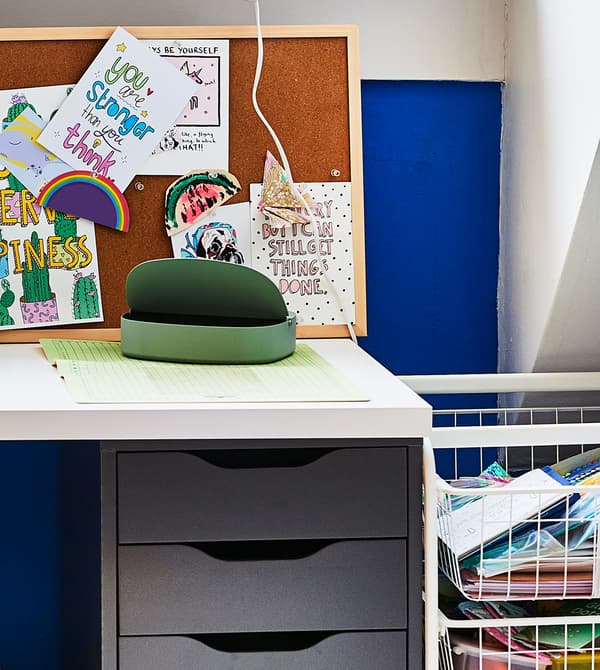 A desk with pinboard and drawer unit.