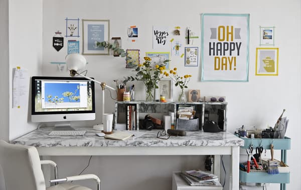 A desk with posters and pictures on the wall 