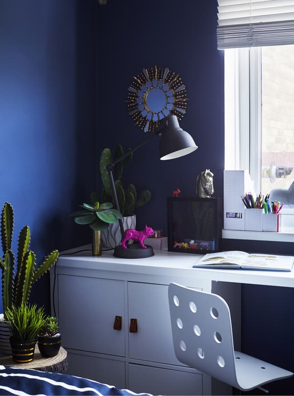 A desk with storage and a lamp.