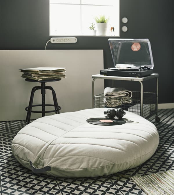 A DIHULT pouffe infront of a LALLERÖD coffee table on the living room floor in a loft apartment.
