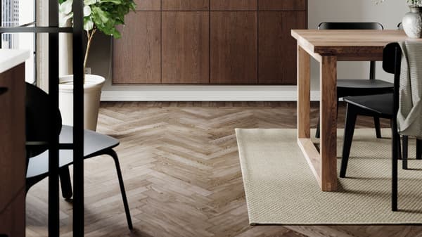 A dining area with a wooden dining table and a beige rug on the floor.