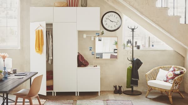 A dining room with clothes storage on a hanger and inside a white IKEA PLATSA storage combination.