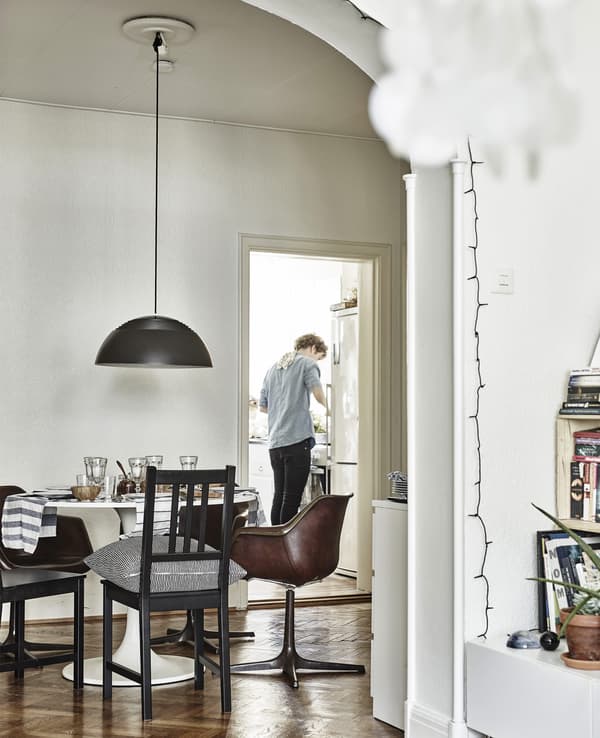 A dining table and chairs with a door through to a kitchen.