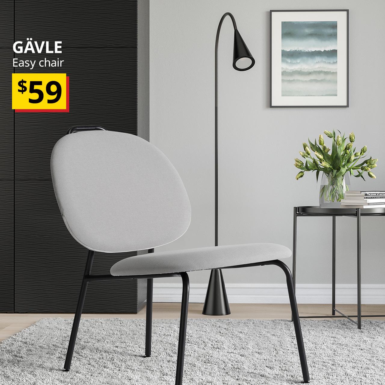 A diseröd grey GÄVLE easy chair placed on a grey rug next to a black GLADOM tray table. On the top left of the image with white text over image that reads "GÄVLE, Easy chair" BTI Price: $59.