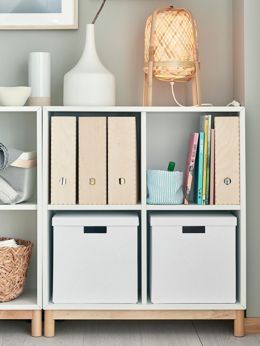 A display cabinet with a riding helmet, a disco globe, some boxes, books and smaller statues.