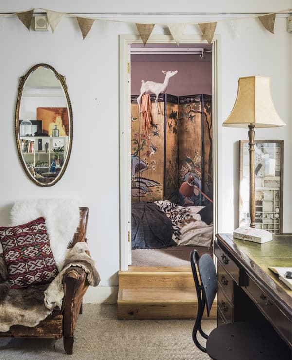 A doorway looking through to a bedroom with clothes screen.
