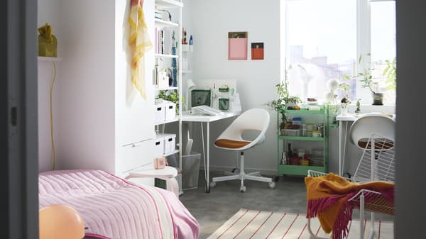 A dorm room with two desks, two chairs and a bed