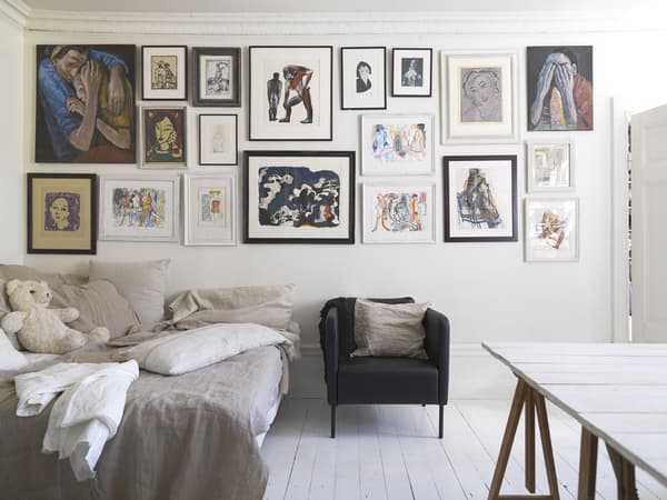 A double bed beneath a gallery wall.