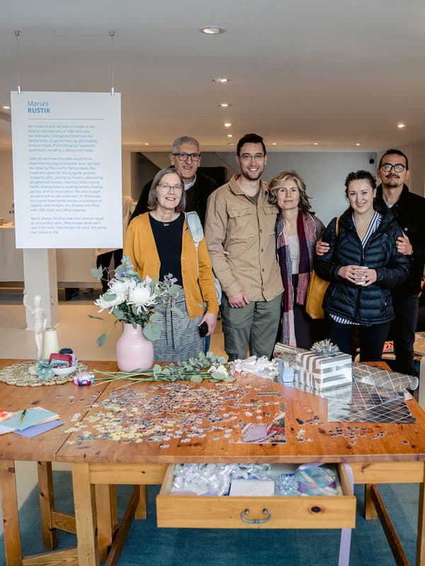 A family poses behind an IKEA RUSTIK table that is on display.