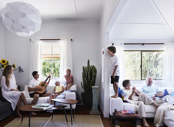 A family relaxing on three sofas in the living room.