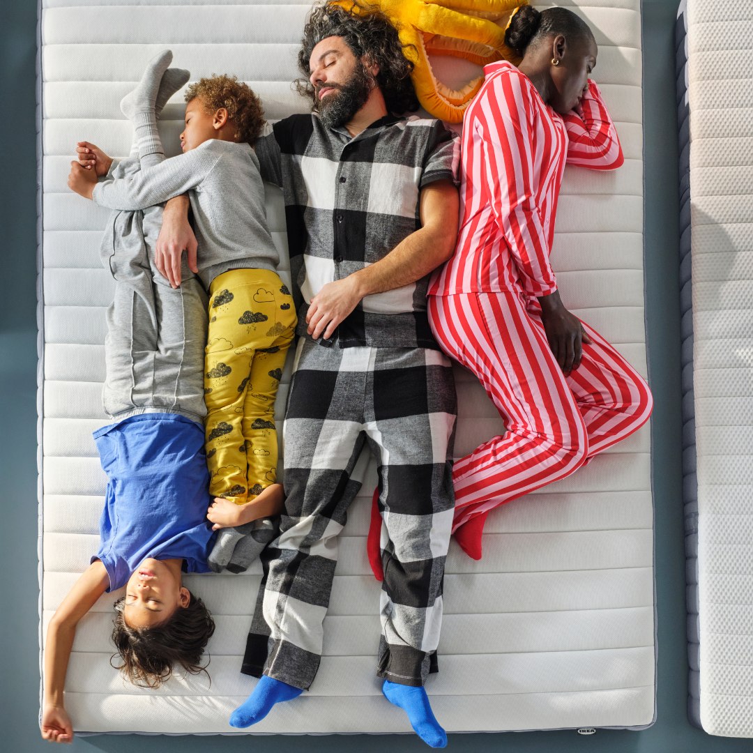 A family sleeping on a bed