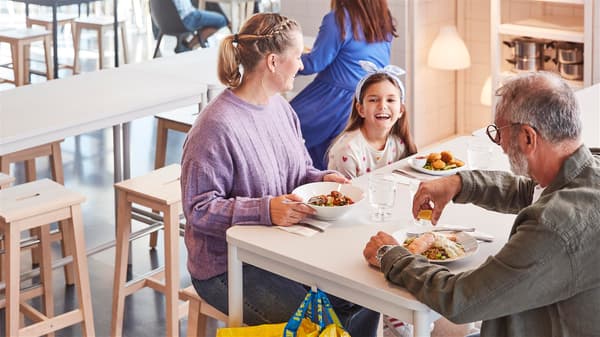 A family with a child is sitting down to eat in an IKEA restaurant.