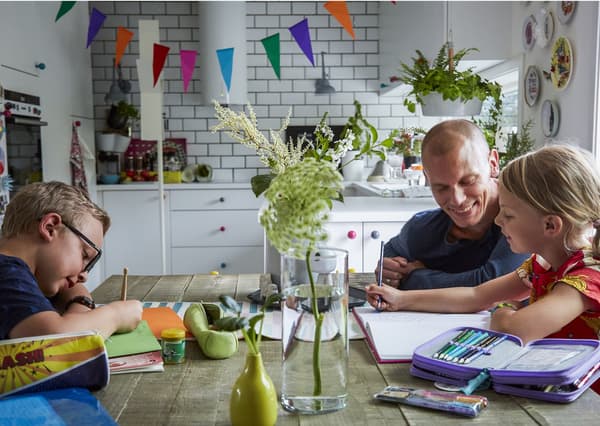 A family working on school books around a table.