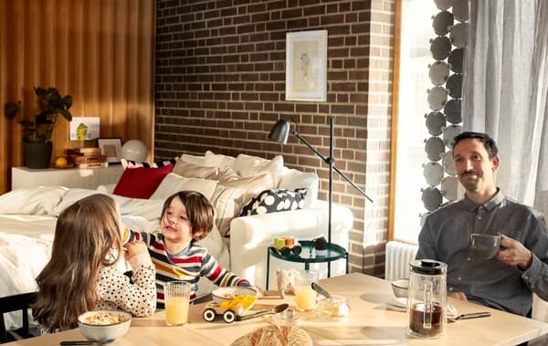 A father sits serenely at the breakfast table drinking coffee