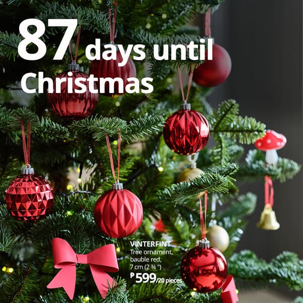 A festive close-up of a Christmas tree adorned with red ornaments and a bow, announcing 87 days until Christmas.