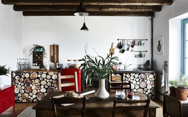 A galley kitchen with aged wood and pops of red.