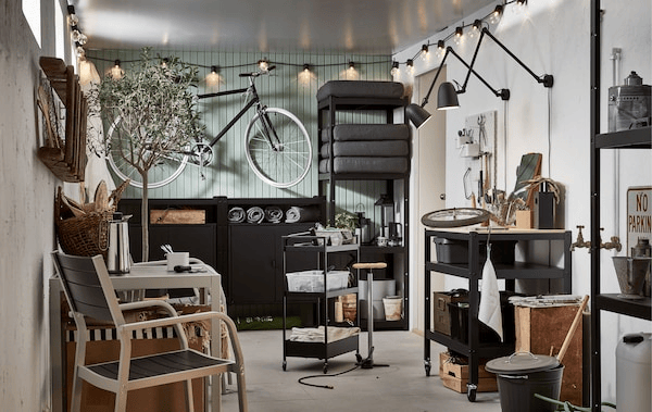 A garage-like interior with wall-hung bike, shelving units with outdoor stuff; seating, coffee, mood and functional lighting.