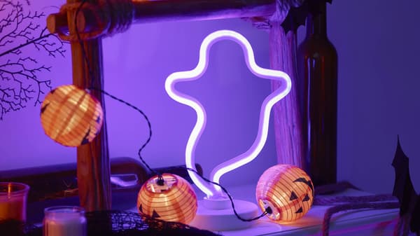 A ghost Halloween light decoration and a string of light pumpkins surrounding it.