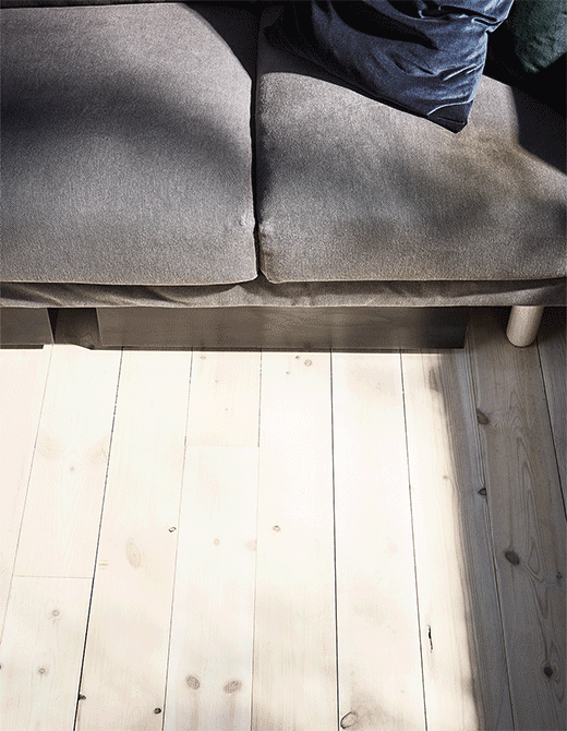 A GIF of a VARDÖ storage box on wheels sliding out from under the sofa to reveal organised home exercise equipment.