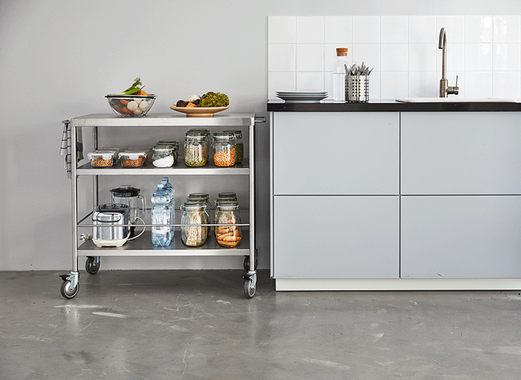A GIF shows a metal kitchen island moving from the centre of the room to its spot next to a kitchen counter.